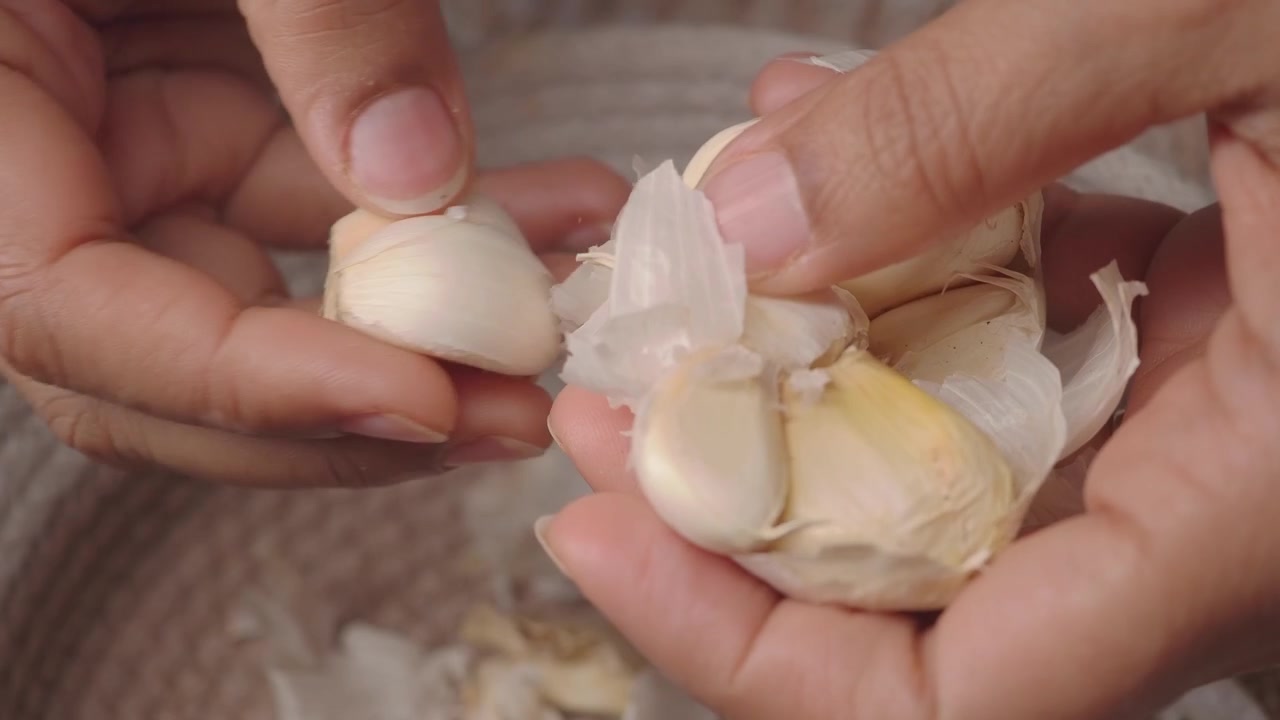 Close-up Tangan Mengupas Bawang Putih Segar