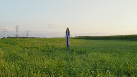 woman in a striped dress in a field at sunset