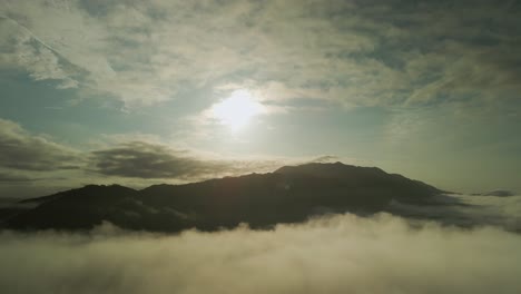 Vuelo-De-Drones-Hacia-Atrás-Desde-El-Sol-Brillante-Sobre-La-Nube-Al-Atardecer,-4k