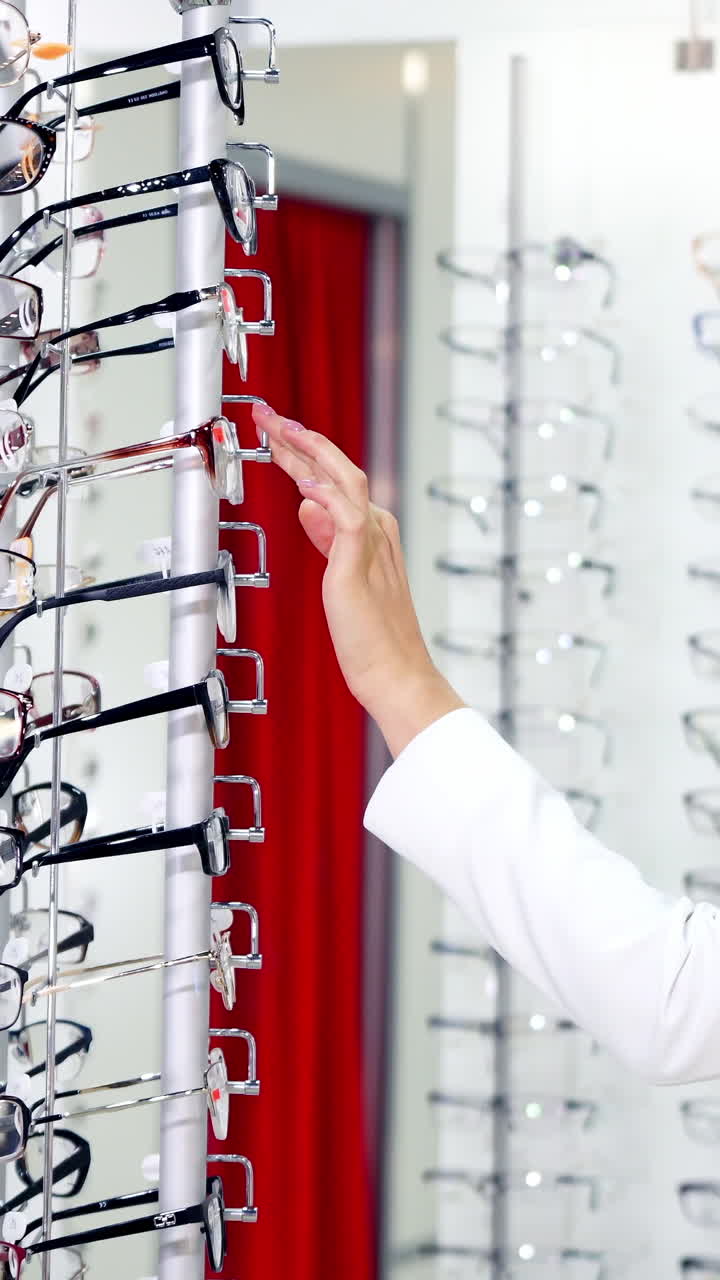Woman trying new eyeglasses. Woman choosing her new glasses at optics store