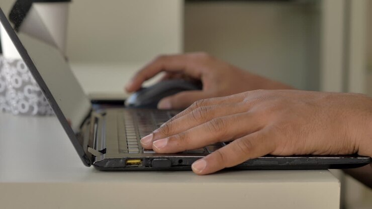 Schnell tippende Hand am Laptop – Kundenservice-Arbeit – drinnen. Laptop-Nutzung.