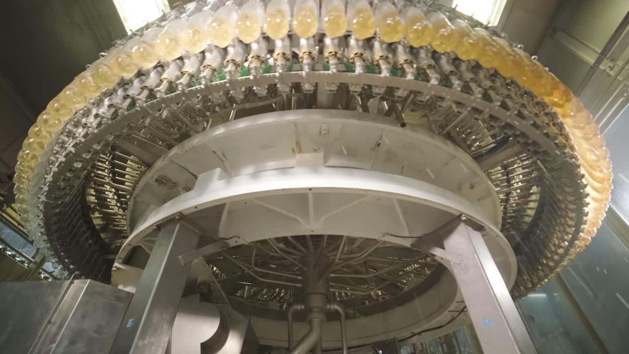 자동 채우기 기계는 현대 음료 공장에서 플라스틱 애완동물 병에 물이나 주스를 습니다.