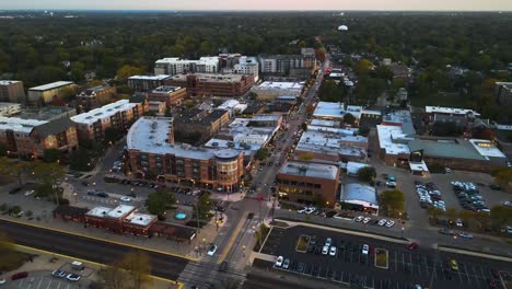 aerial capture of downers grove illinois at dusk featuring illuminated streets and urban landscape. crane up dusk s