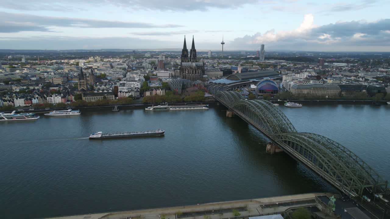Inland tanker sailing under the green Hohenzollernbrücke with the skyline of Köln in the background