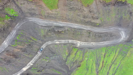 Disparo-De-Dron-En-ángulo-Descendente-De-Un-Vehículo-Conduciendo-Por-La-Carretera-A-Tusheti,-Una-De-Las-Carreteras-Más-Peligrosas-Del-Mundo