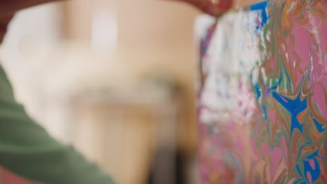 girl looks at picture with ebru patterns held by woman