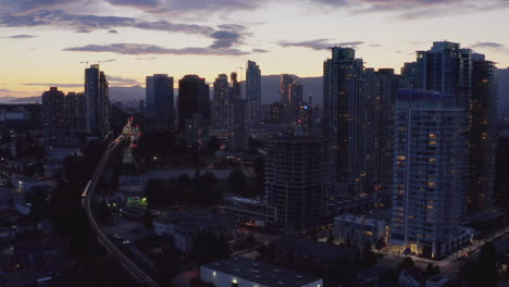 Aerial-reverse-orbiting-sunset-view-of-Burnaby,-British-Colombia-city-skyline