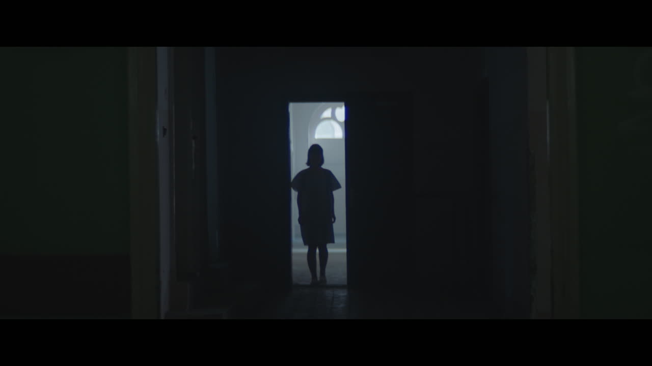 A girl in a dark corridor at night