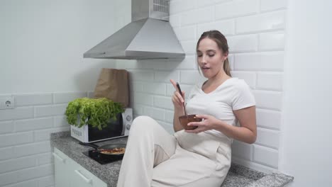 woman enjoying a healthy meal in her kitchen