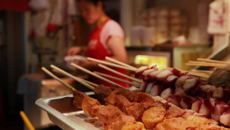 vendor preparing skewers at a food stall