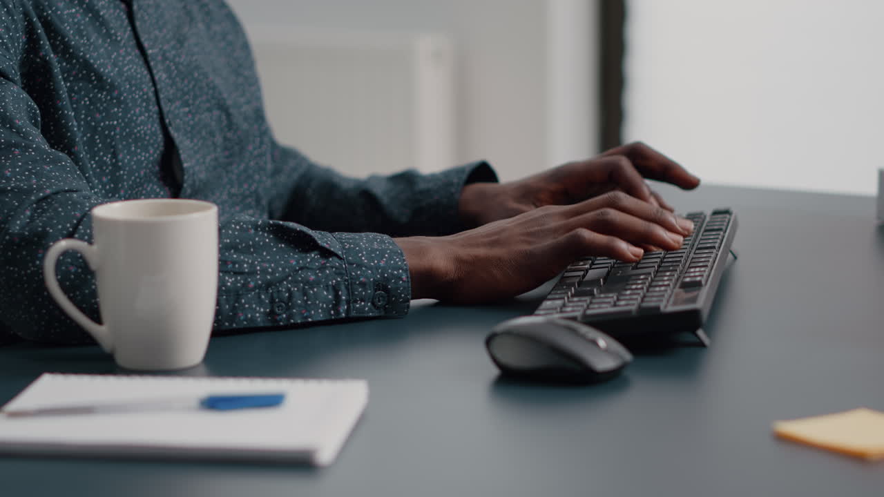 Close up of african american man hands typing on computer keyboard