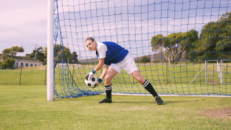 goalkeeper in blue making a save