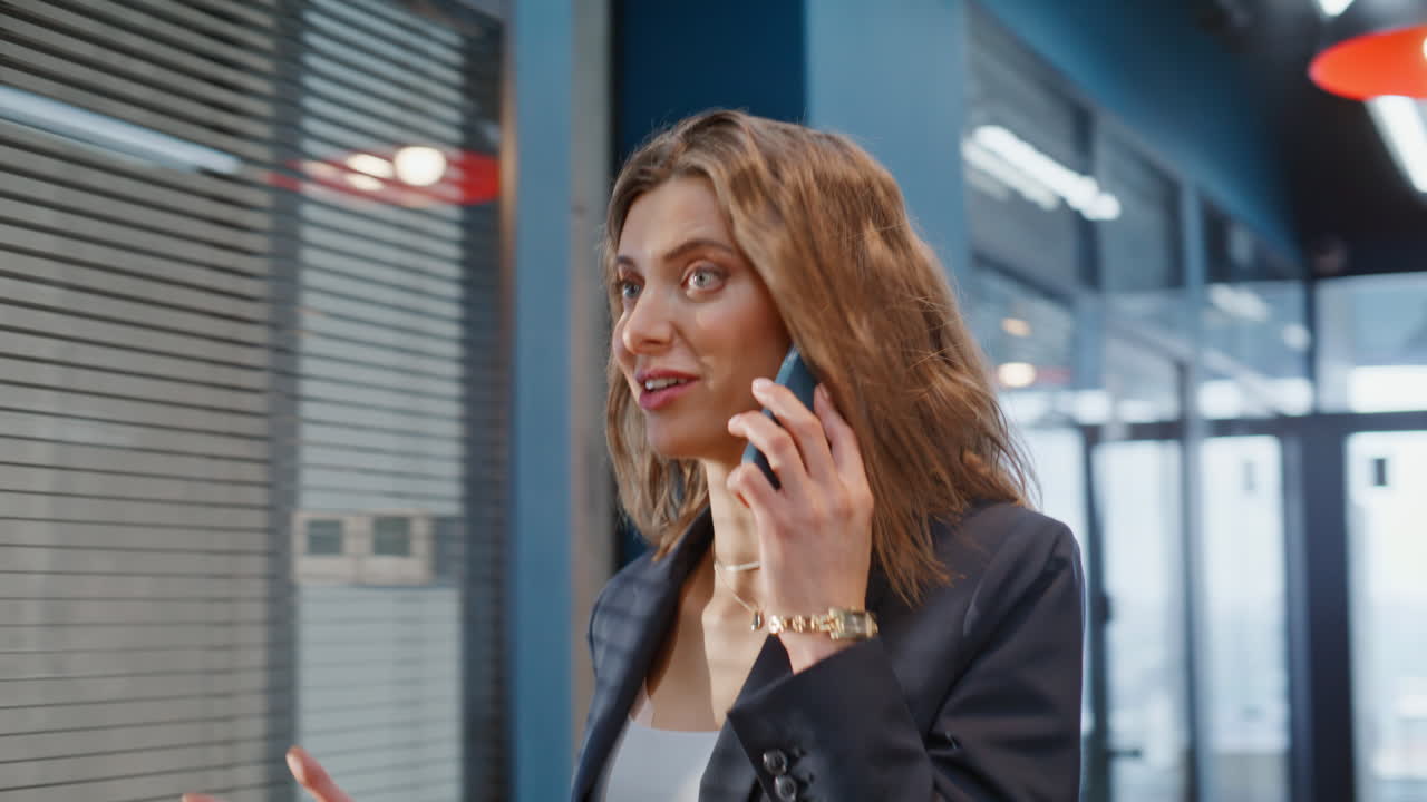 Happy leader talking cellphone walking office corridor closeup. Smiling woman