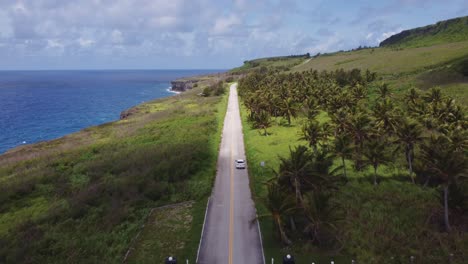 Toma-De-Drone-De-Un-Automóvil-Moviéndose-A-Lo-Largo-Del-Acantilado-Banzai,-Isla-Tinian