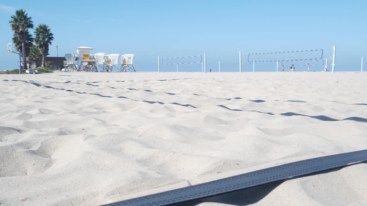 해변 코트에서 볼리볼을 하는 선수들, 공과 그물로 볼리볼 게임을 하는 선수들.