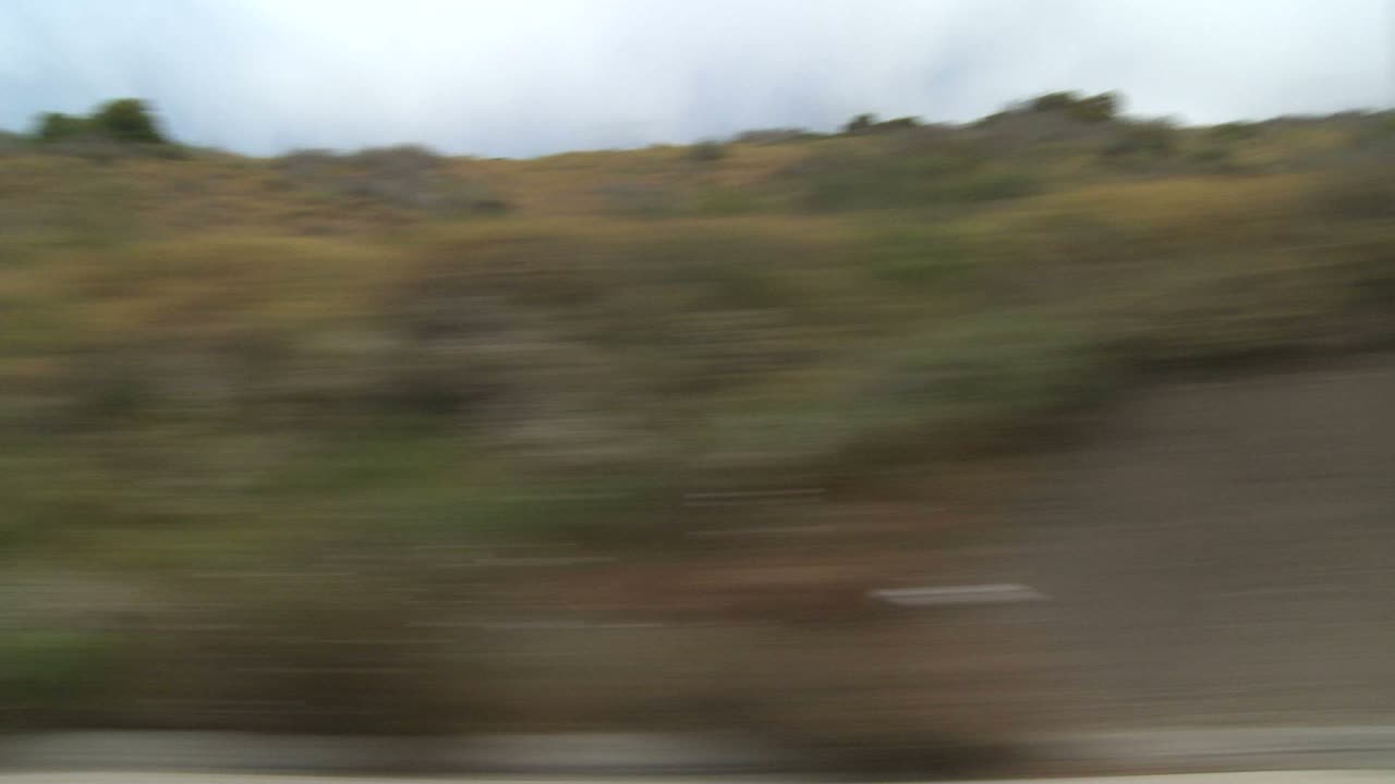 un automóvil viaja a lo largo de la carretera de la costa pacífica como se ve a través de la ventana lateral 8