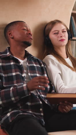 friends discuss movie seen in library. black man and blonde woman talk watching informative video in modern college library. place for self-development