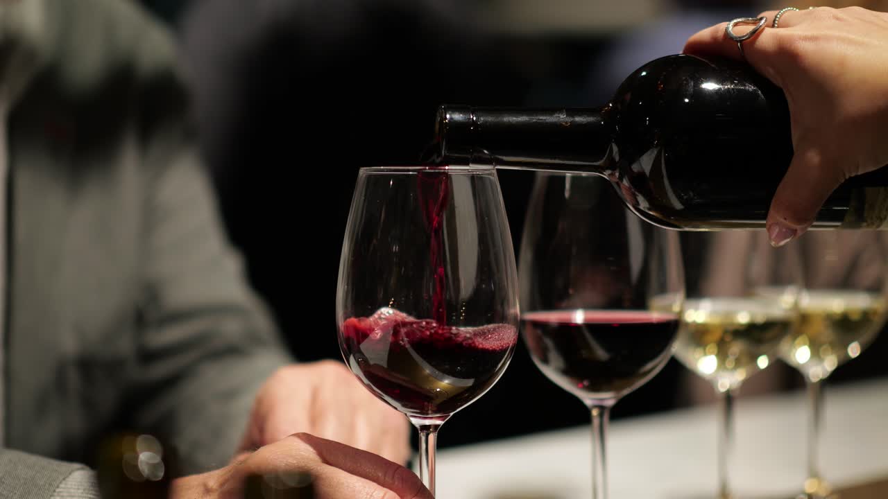 Pouring red wine into glass in indoor space