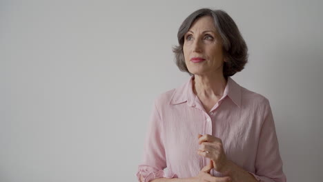 Intrigued-Elderly-Woman-Thinking-With-Hand-On-Chin-Looking-Up-On-White-Background