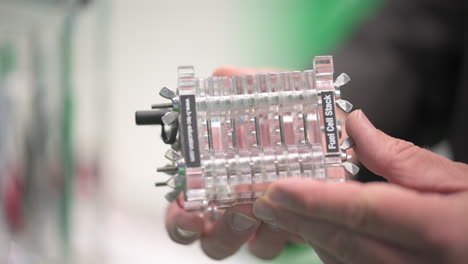 hands holding a fuel cell stack to generate electricity from hydrogen and air