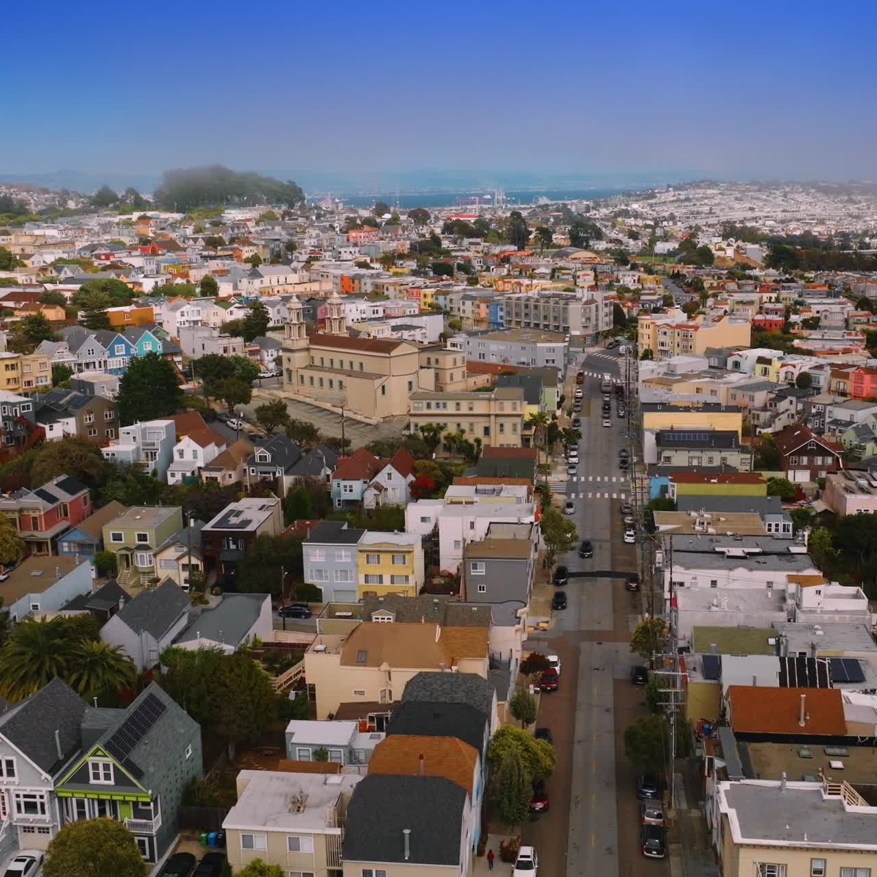Beautiful cozy streets and houses of bright San Francisco, California, USA. Sunny cityscape with hazy horizon at the backdrop of blue sky