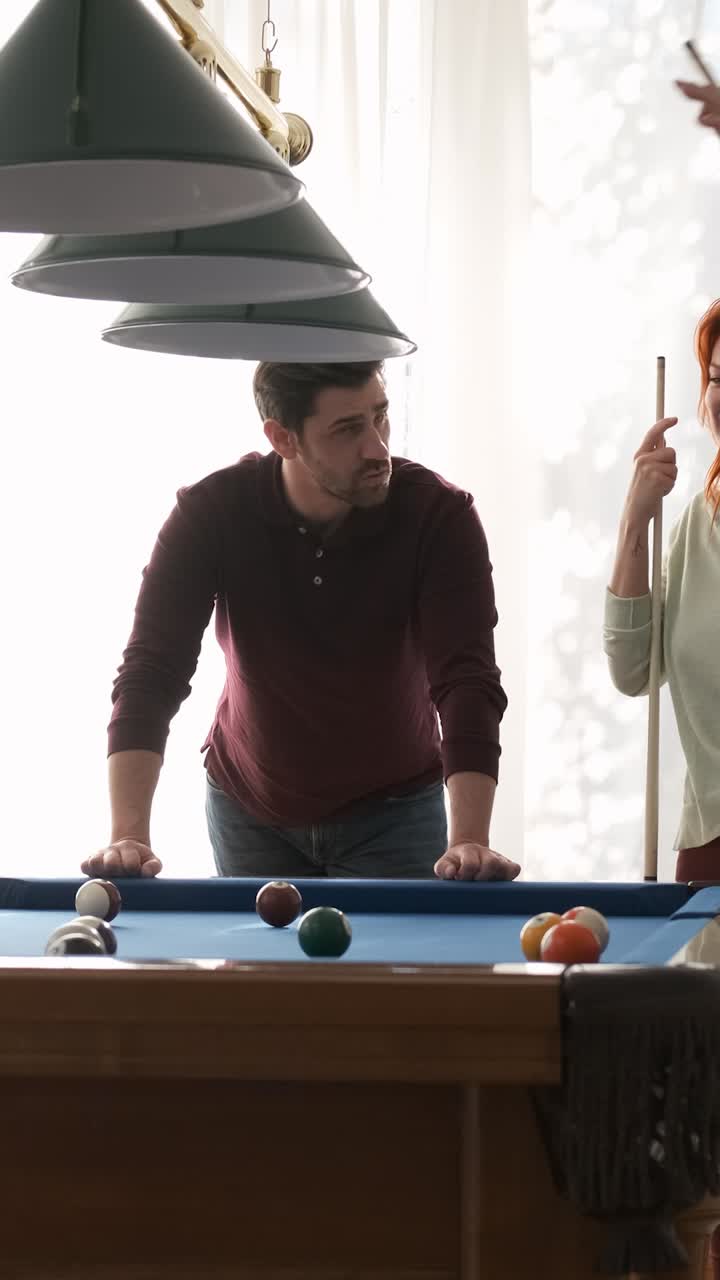 Friends playing pool together in game room on weekend