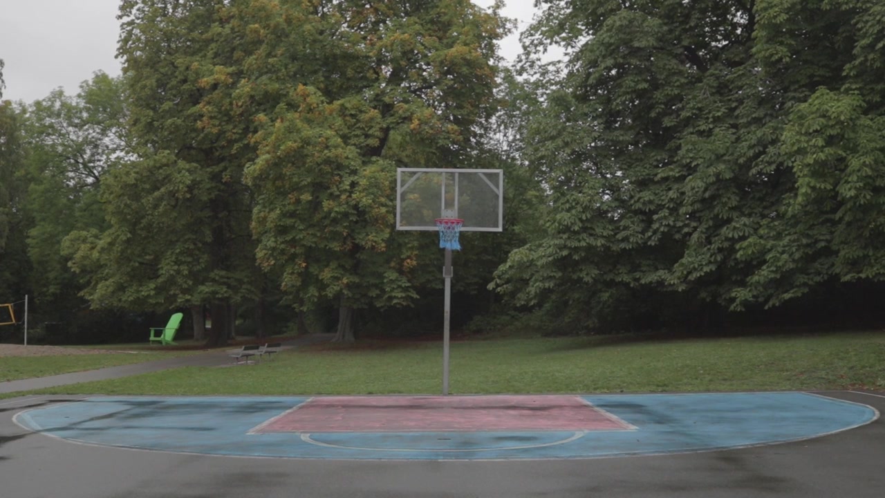 Empty outdoor basketball court surrounded by green trees in Bygdoy