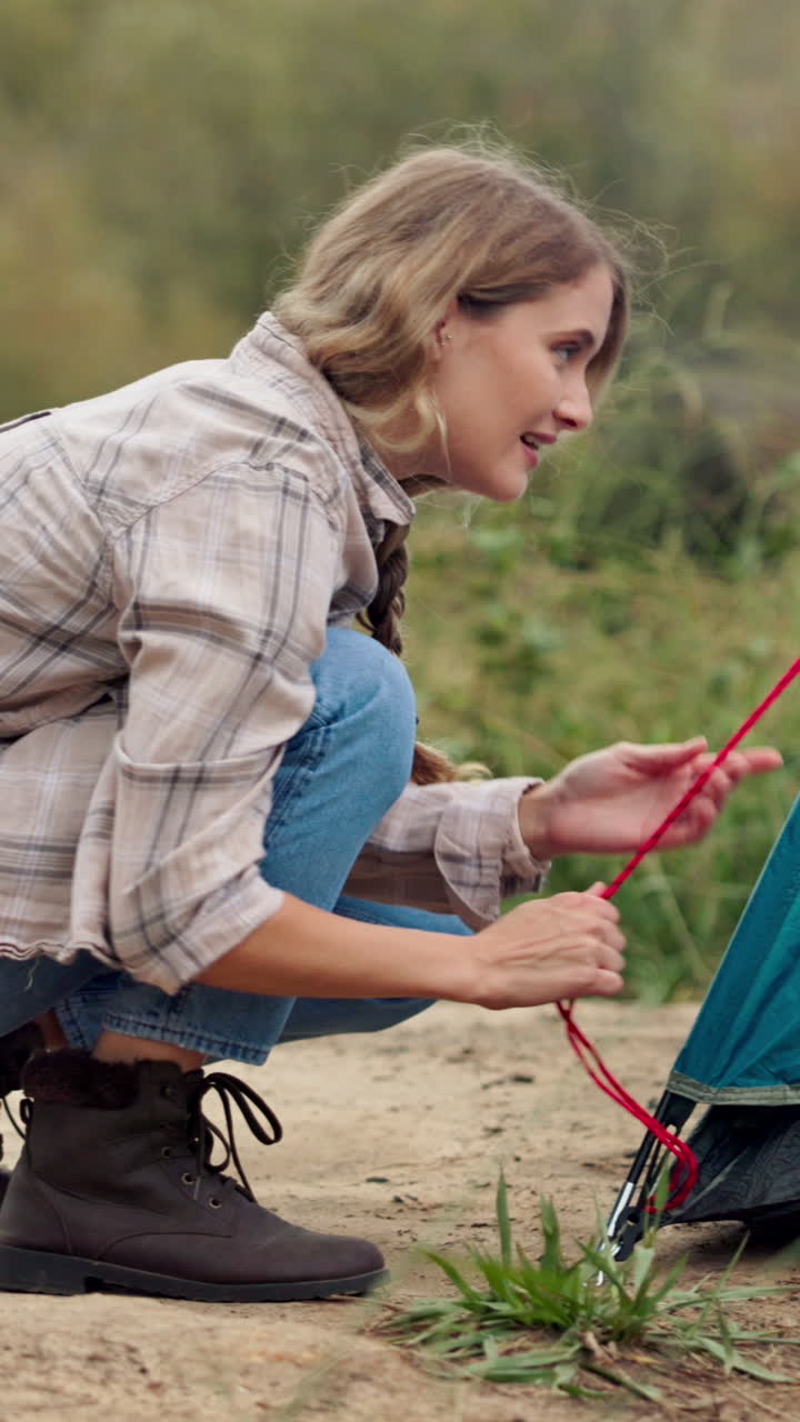 Woman camping and setting up a tent