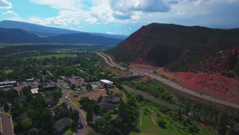 Carbondale-Roaring-Fork-River-Glennwood-Springs-Aspen-Snowmass-summer-aerial-drone-Colorado-June-July-Rocky-Mountain-snow-cap-peaks-Marble-El-Jebel-Marble-Basalt-clouds-sunny-forward-pan-up-motion