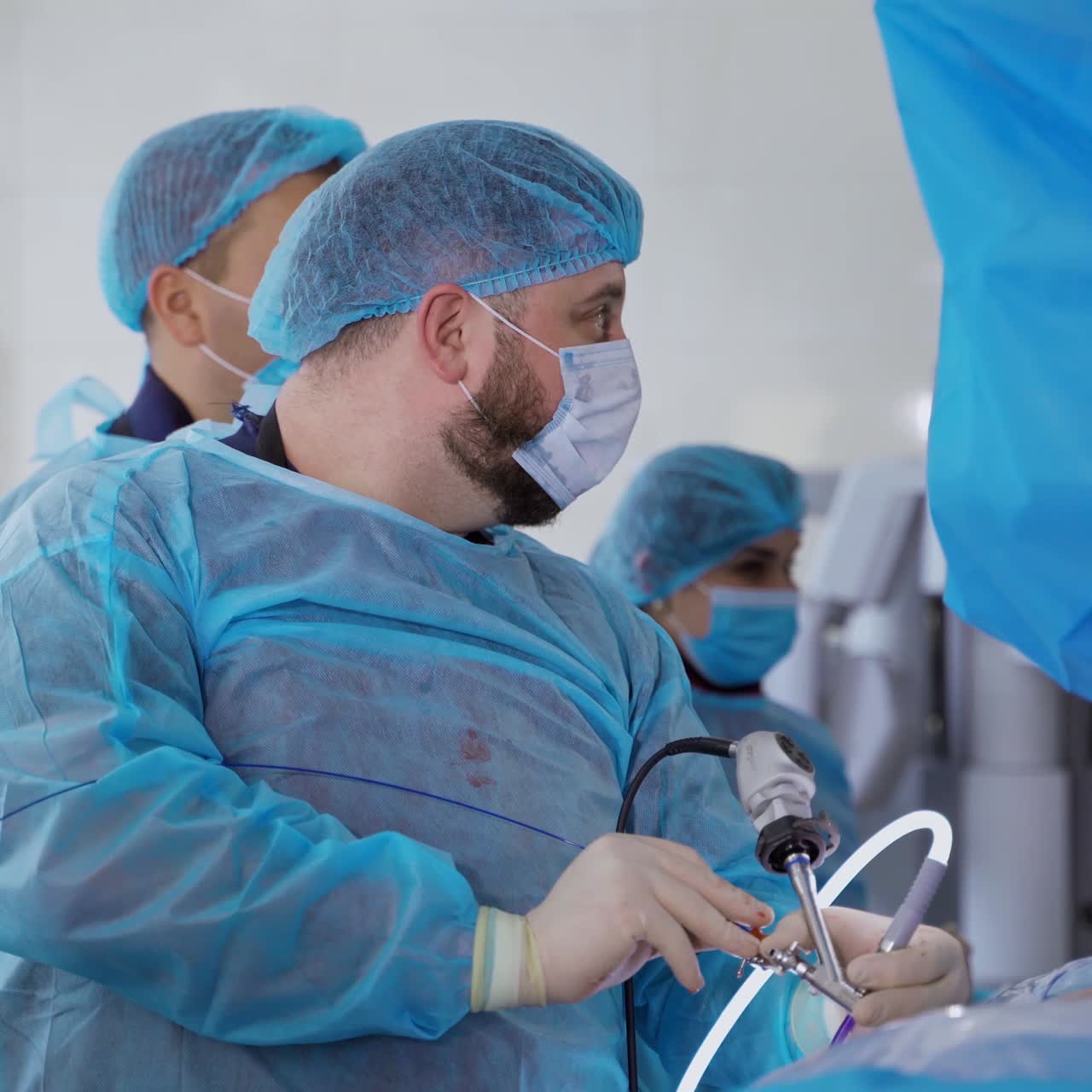 Group of doctors in medical uniform in the operating room. Professional surgeon performing a surgery on kidneys using medical equipment in clinic.