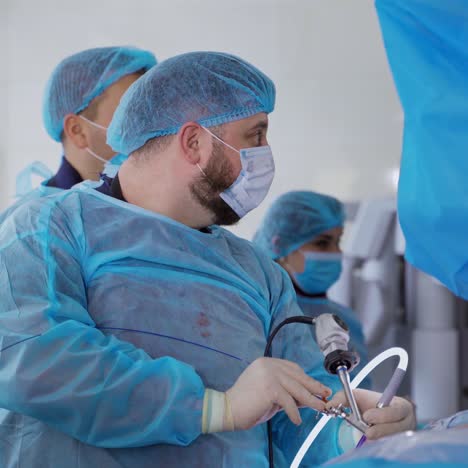 group of doctors in medical uniform in the operating room. professional surgeon performing a surgery on kidneys using medical equipment in clinic.