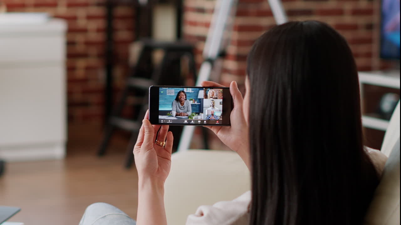 Woman using smartphone for a video call at home