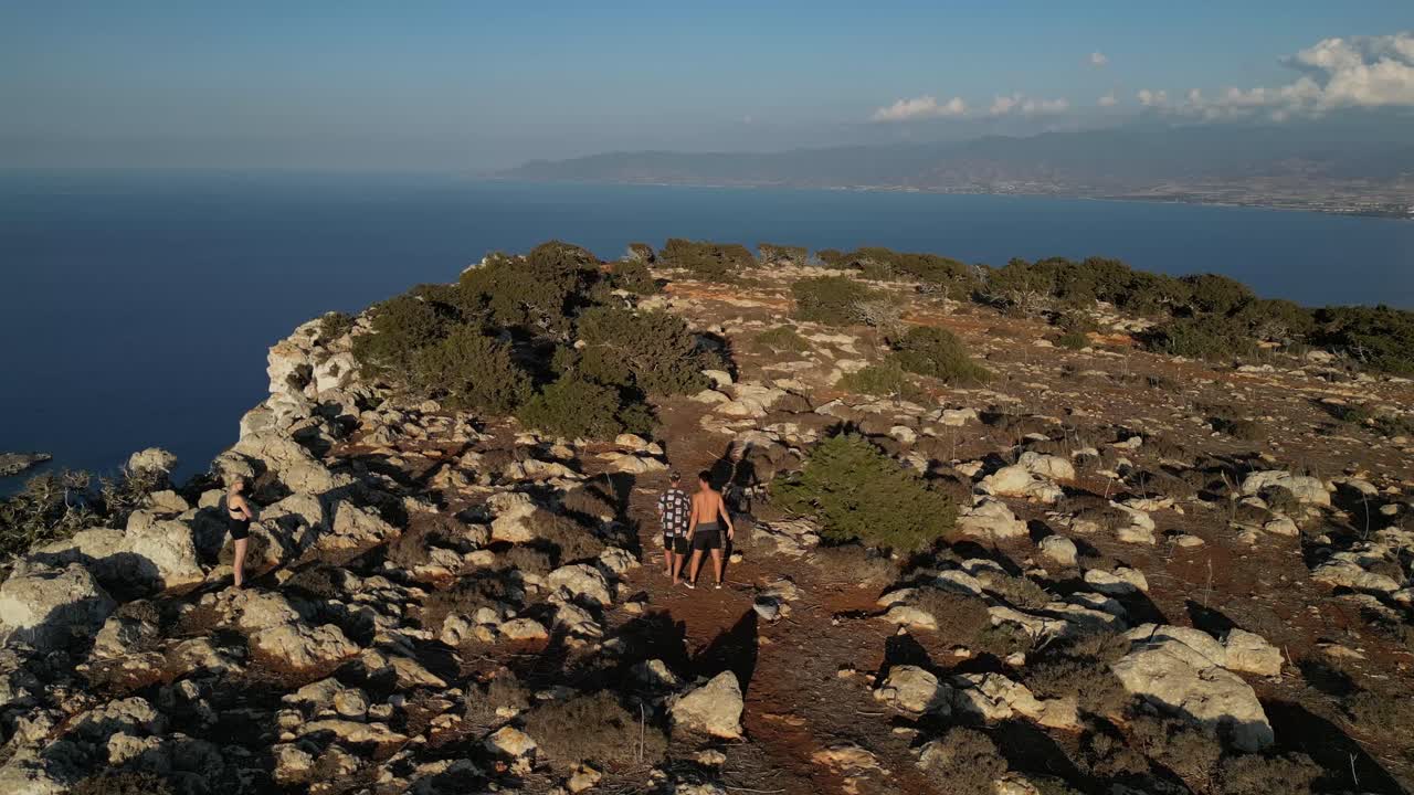 Two Men Hiking on a Cliff overlooking the Ocean
