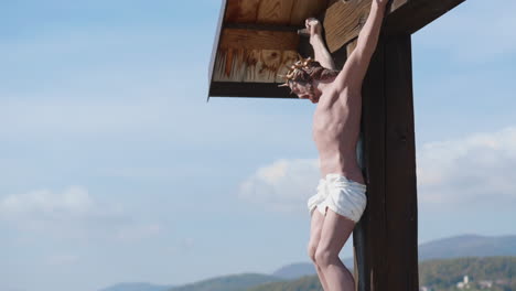 statue of jesus christ on the cross, against a cloudy sky