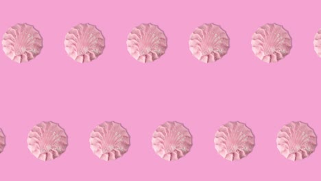 animación de bucle sin costuras con dos filas de muchos marshmallows rosados en un fondo rosado, espacio de copia