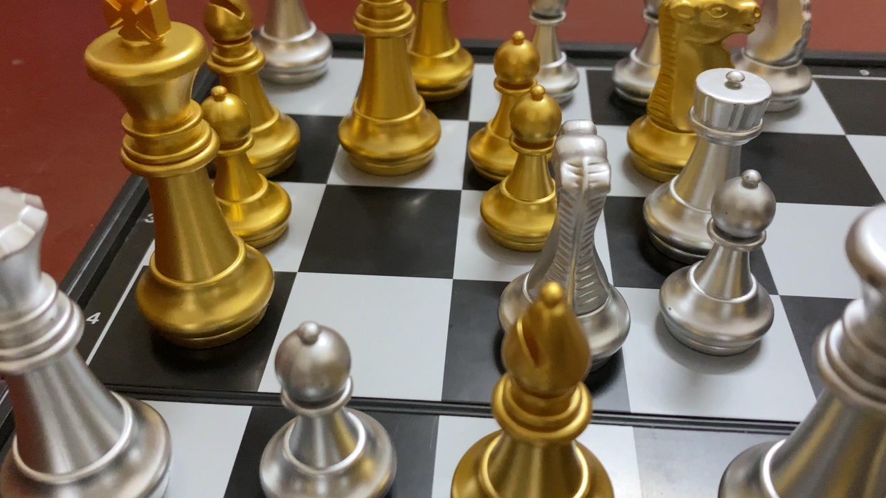 Close up view of silver and gold Chess set on classic black white board