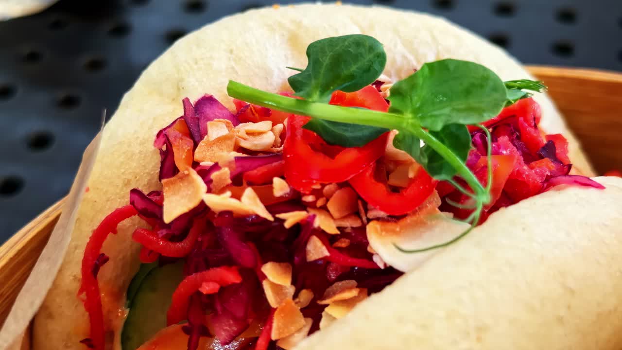 Panini cinesi cotti al vapore ripieni di vivaci verdure tagliate alla julienne e guarniti con erbe fresche - Primo piano