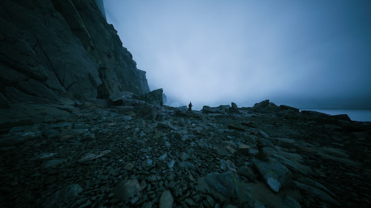 A Person on a Rocky Beach in Fog