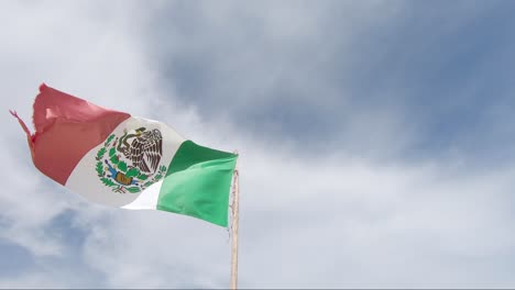 Mostrando-La-Bandera-Mexicana-Contra-Un-Cielo-Azul