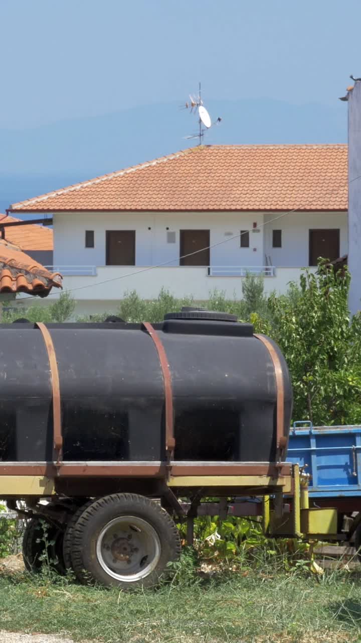 Water tank on a trailer in front of a house