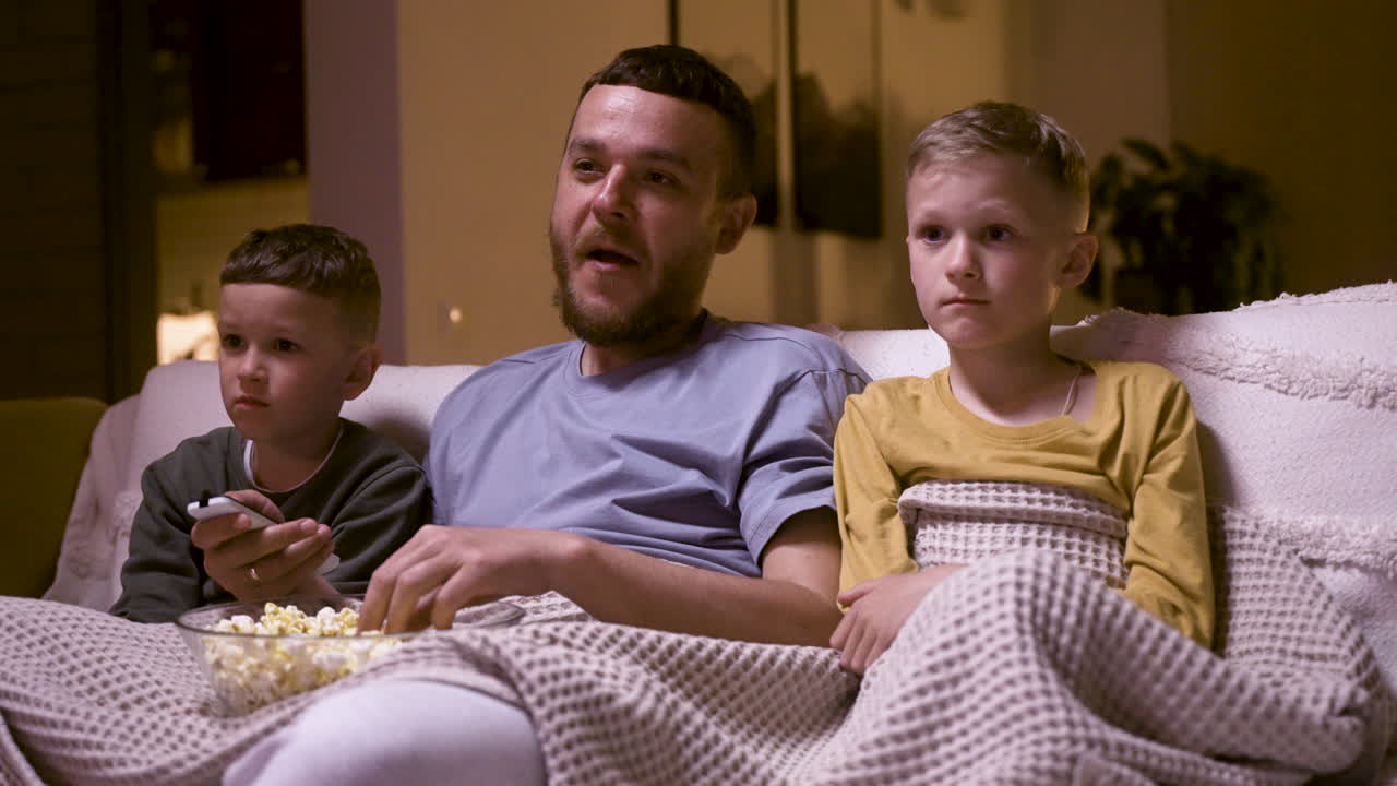 Father and sons watching funny movie