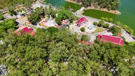 imágenes de drones capturan el templo de wat nai harn en phuket, tailandia, destacando su arquitectura y la vegetación circundante bajo la luz del día.