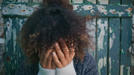 upset woman standing vintage door at windy nature closeup. depressed lady crying