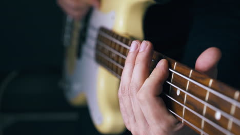 el músico toca el bajo blanco conectado al amplificador.