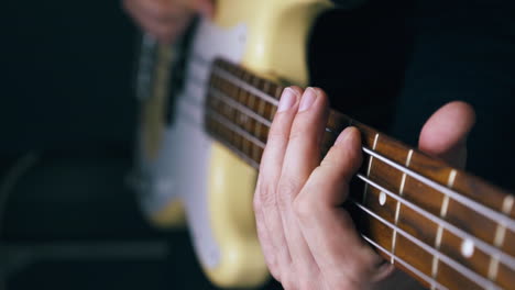 musician plays white bass guitar connected to amplifier