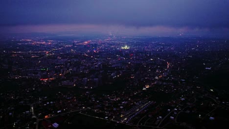 epic drone of prishtina city at twilight, misty horizon, vibrant urban lighting