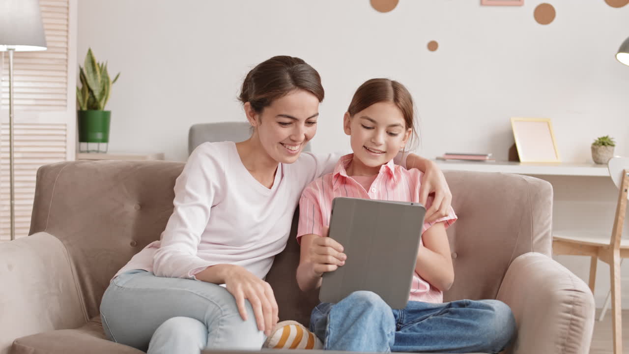 escolar y su mamá usando una tableta digital en casa
