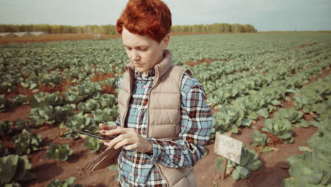 mujer usando una tableta digital en el campo de la granja