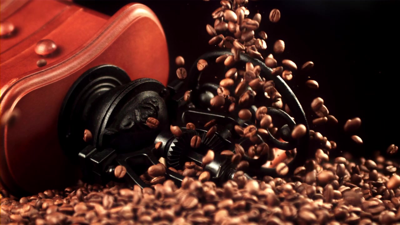Roasted Coffee Beans Falling onto an Antique Coffee Grinder