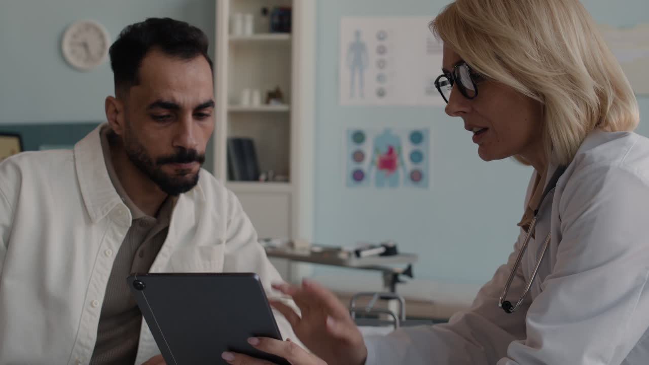 Doctor consulting patient with tablet